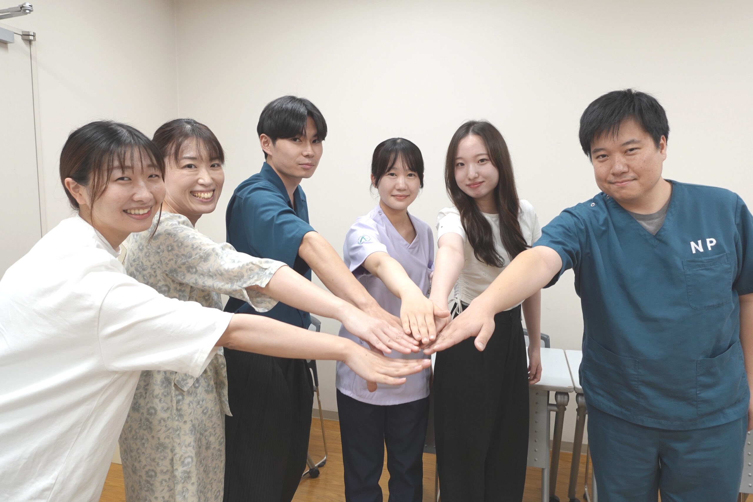 新任理事と先輩役員が力を合わせる様子